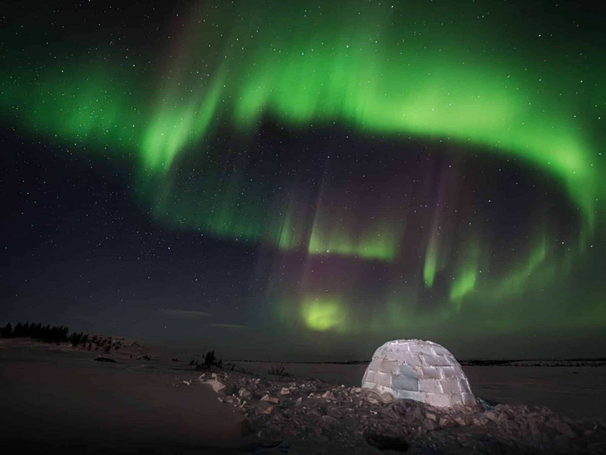 aurora borealis above a lit up igloo in Nunavik with Ungava tour
